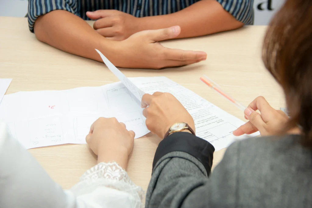 Close-up of hands on an office desk during a job interview detecting red flags and workplace gaslighting signals